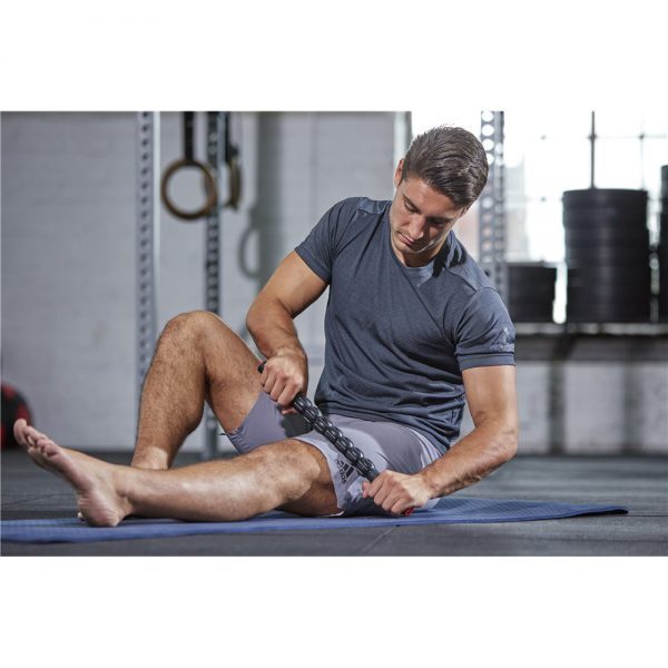 Person using Adidas Massage Roller on blue mat for leg point pain relief