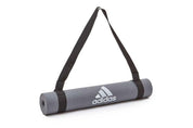 Grey Adidas yoga mat with black shoulder carry strap for easy transport and storage