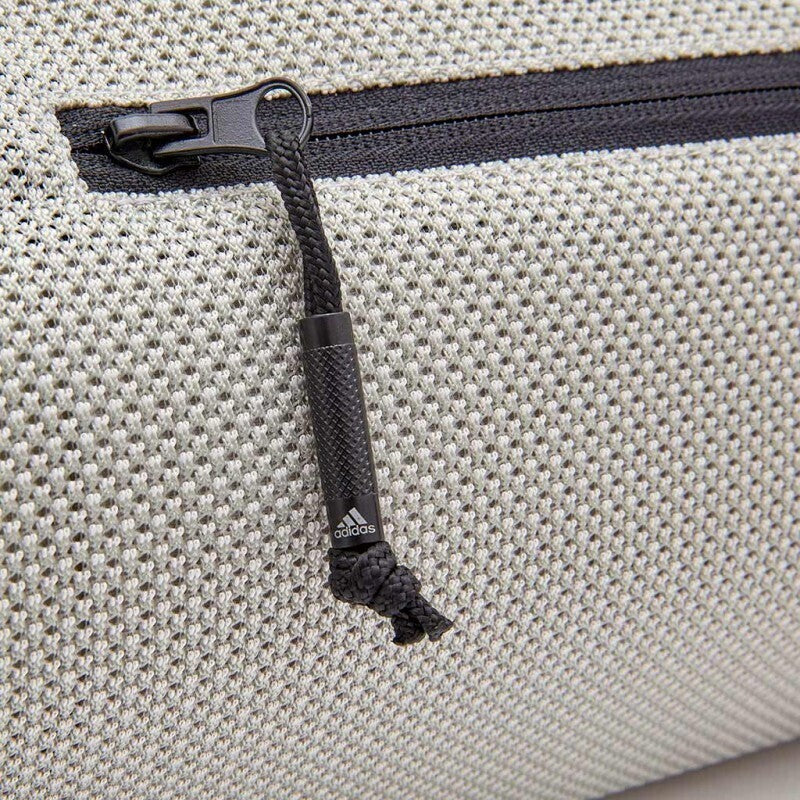 Black zipper pull with Adidas logo on textured fabric of Adidas yoga mat carrier bag