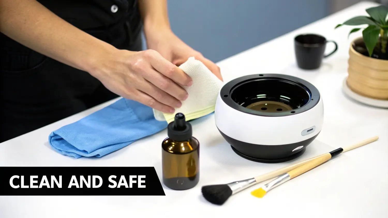 Hands wiping a modern aromatherapy diffuser with a white cloth, surrounded by essential oils and brushes for a clean setup.