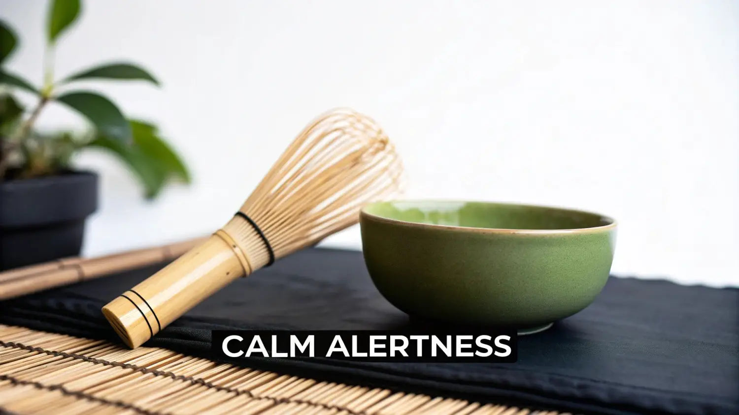 Bamboo matcha whisk and green ceramic bowl on black cloth for Japanese tea ceremony