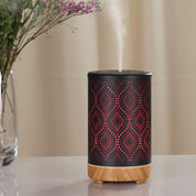 Metal and wood essential oil diffuser with geometric cutouts emitting ultrasonic aroma steam