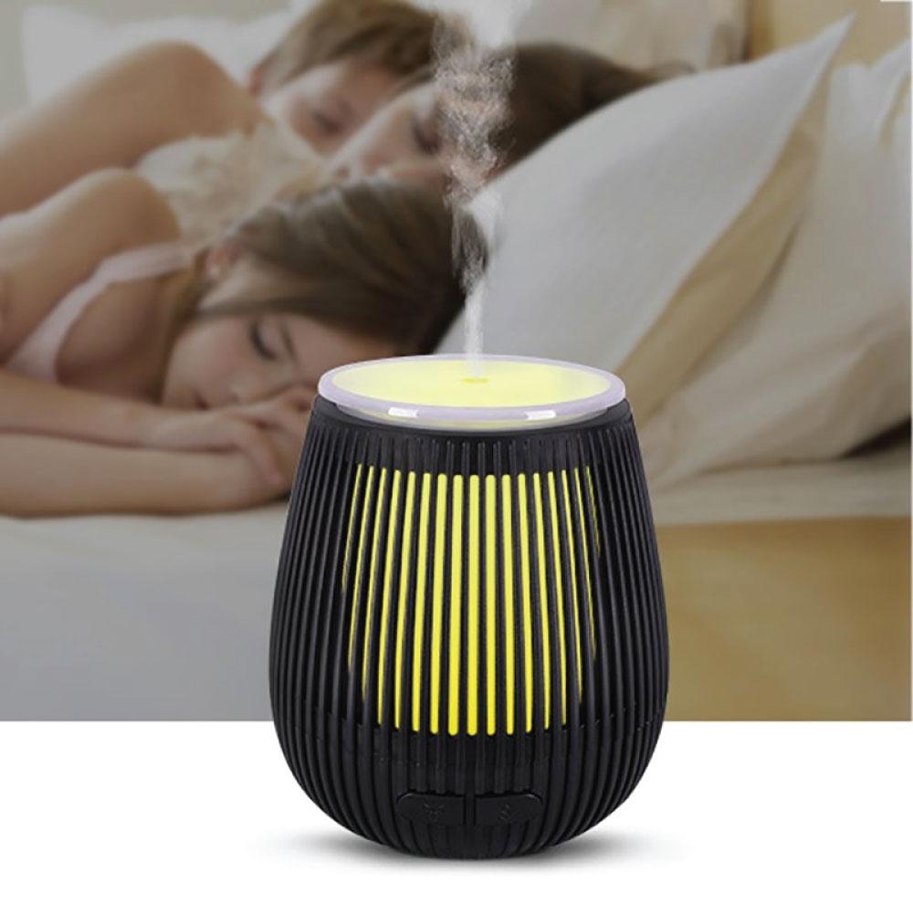 Black ribbed essential oil aroma diffuser with yellow glow and vertical slats