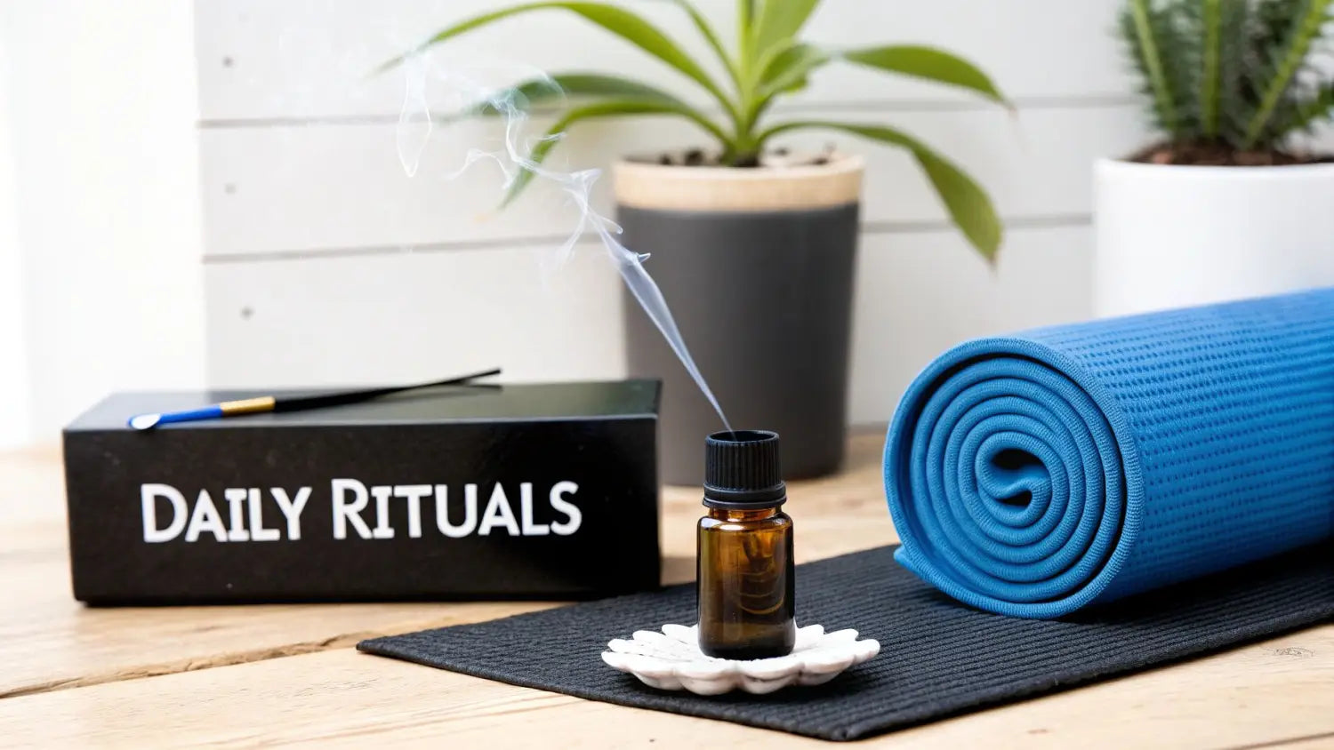 An amber essential oil bottle emitting smoke, next to a blue yoga mat and a 'DAILY RITUALS' box.