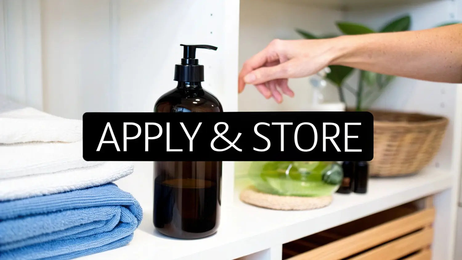 Hand reaching for amber glass pump bottle of magnesium oil on bathroom counter with towels