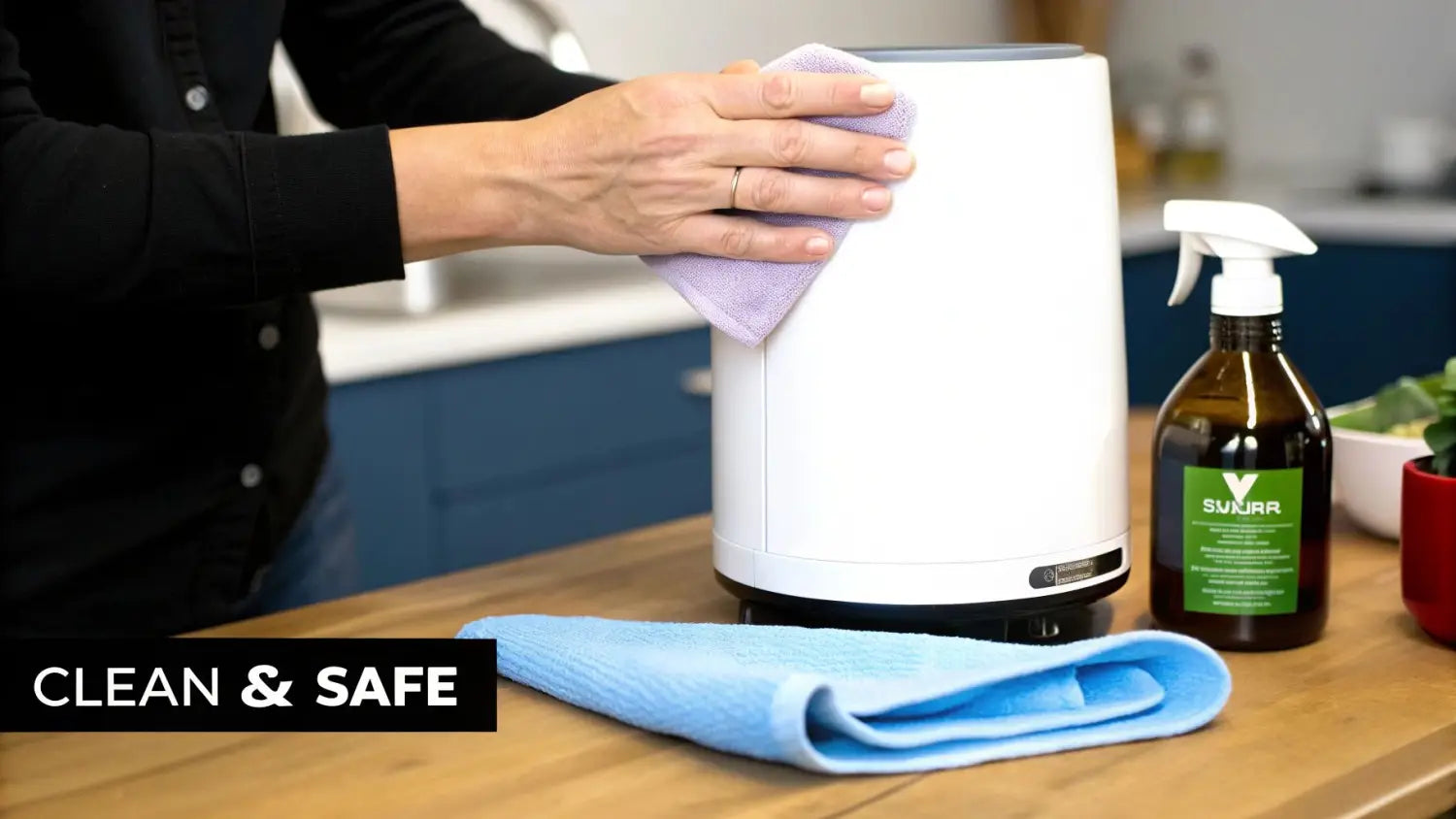 A person cleans a white humidifier with a purple cloth, with cleaning spray and a blue cloth nearby.