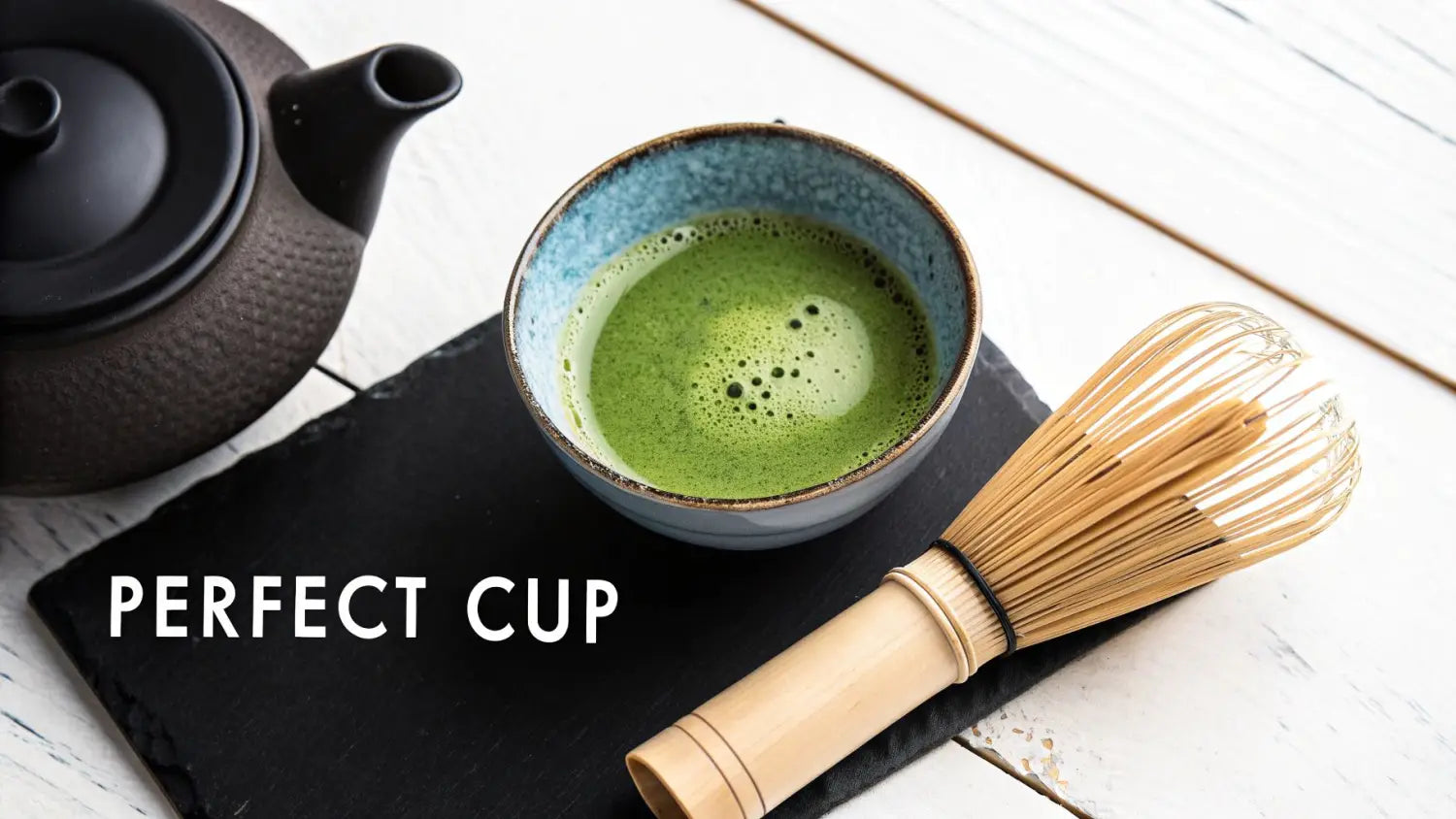 A traditional matcha tea set featuring a black teapot, vibrant green matcha, and a bamboo whisk.