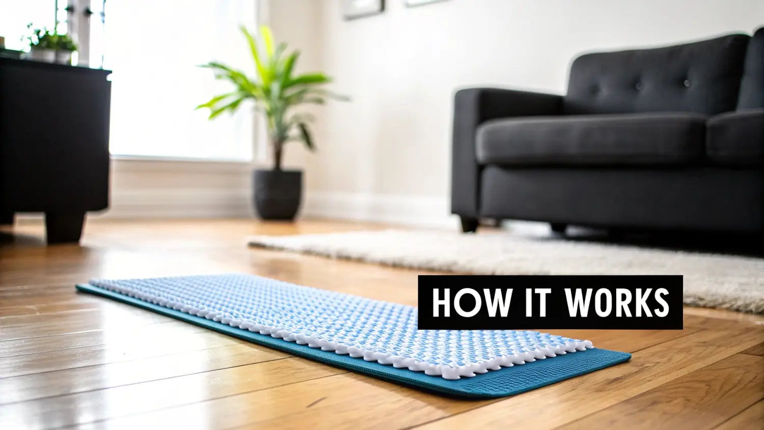 A blue and white acupressure mat lays on a wooden floor in a bright living room setting.