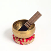 small singing bowl on cushion with wand